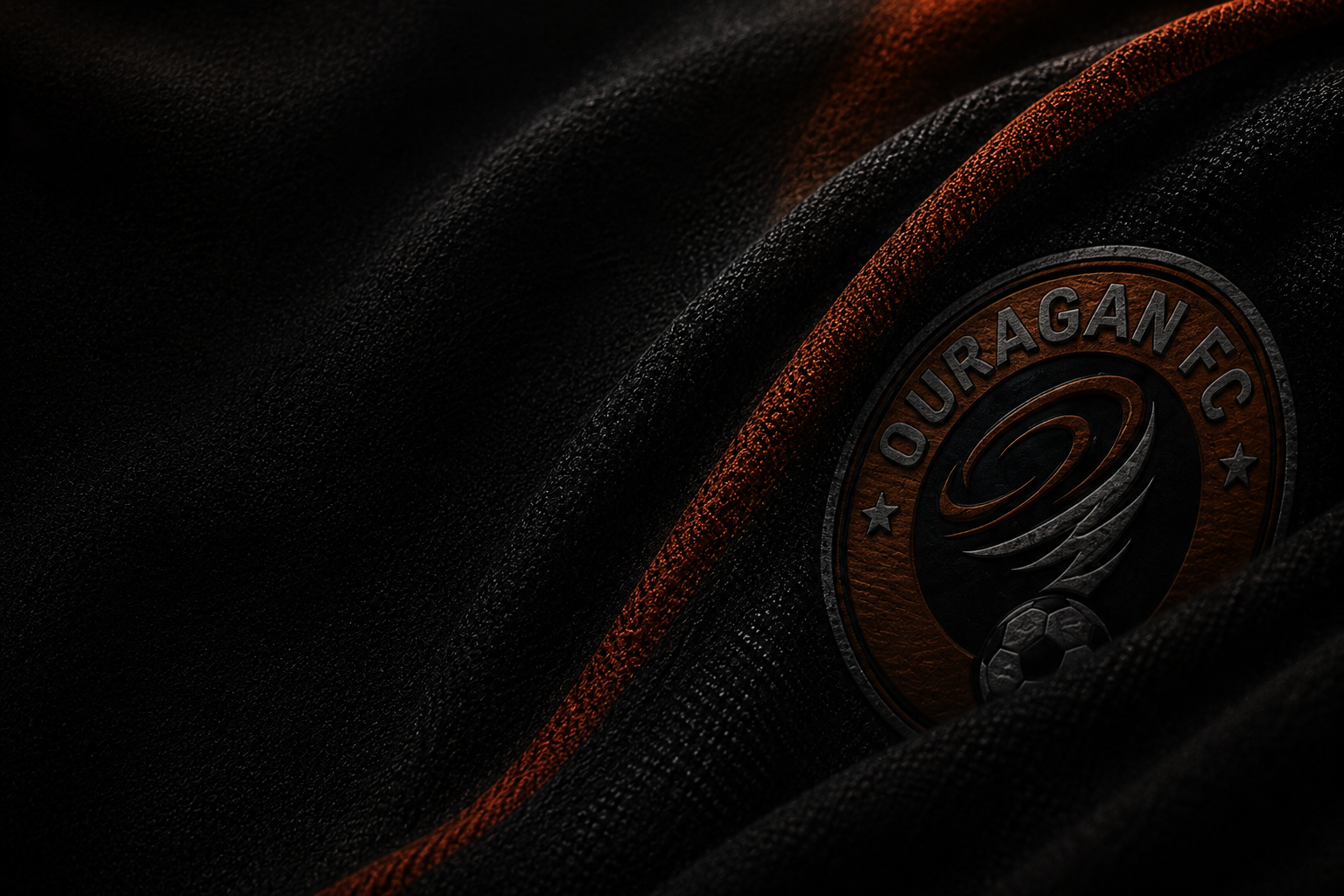 Blason Ouragan FC incliné et fondu dans les plis d’un textile noir et orange